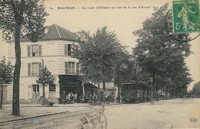 221_001_cpa-92-bagneux-route-d-orleans-au-coin-de-la-rue-d-arcueil-et-le-tramway